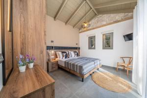 Schlafzimmer mit einem Bett und einem Tisch in der Unterkunft F&A Golden Stone Villa in Loukáta