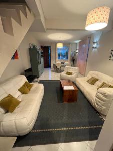 a living room with two white couches and a table at Maison Sandra Montchoisy in Mont Choisy