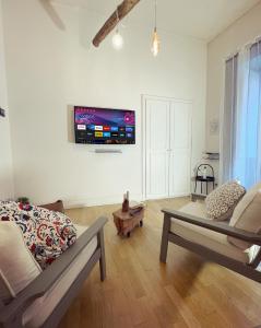 a living room with a couch and a tv on the wall at Lovely Home Marta in Pozzuoli