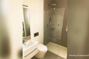 a bathroom with a shower and a toilet and a sink at Contemporary 1 Bedroom Loft in Ilford, London in Ilford