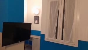 a television sitting next to a window with a curtain at Hotel Villa Argentina in Riomaggiore