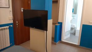 a flat screen tv on a stand in a room at Hotel Villa Argentina in Riomaggiore