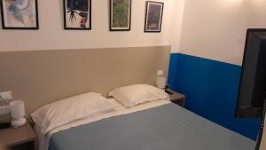 a small bedroom with a bed and a tv at Hotel Villa Argentina in Riomaggiore