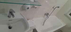 a white bathroom with a sink and a shower at Hotel Villa Argentina in Riomaggiore