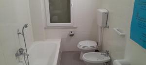 a white bathroom with a toilet and a sink at Hotel Villa Argentina in Riomaggiore