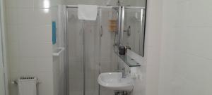 a white bathroom with a sink and a mirror at Hotel Villa Argentina in Riomaggiore