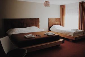 a bedroom with two beds and a chair and a window at Popasul Graniceresc in Năsăud