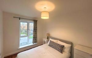 - une chambre avec un lit blanc et une fenêtre dans l'établissement Taplow Stunning Four Bedroom Townhouse, à Taplow