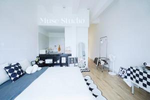 um quarto branco com uma cama grande e almofadas pretas e brancas em Muse Studio @CBD with pool em Gua Musang