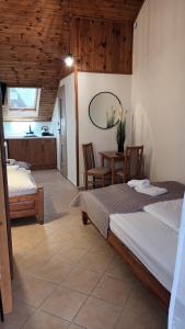 a room with two beds and a table and a kitchen at Pensjonacik Ewa in Darłowo +35 photos