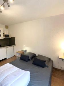 1 dormitorio con 1 cama con 2 almohadas en Studio Paisible Cœur de Paray-Le-Monial app 303 en Paray-le-Monial