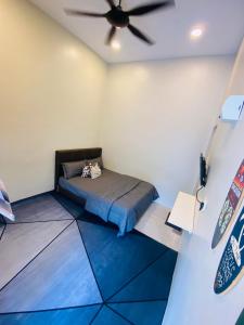 a room with a bed and a ceiling fan at AzHAUZ Guestroom & Campsite in Kemaman