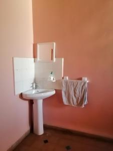 a bathroom with a white sink and a towel at Gite chez Ali Agouti Maison Berbère in Idoukaln