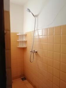 y baño con ducha y azulejos de color naranja. en Gite chez Ali Agouti Maison Berbère en Idoukaln