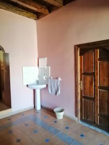een badkamer met een wastafel naast een deur bij Gite chez Ali Agouti Maison Berbère in Idoukaln