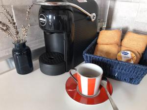 a cup of coffee on a plate next to a toaster at Cà Rosa in Poviglio