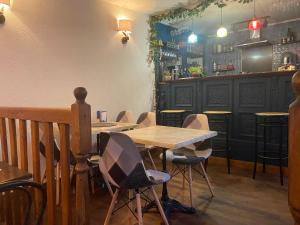 una mesa y sillas en un restaurante con bar en Moon River Bellac Chambre d'hotes, en Bellac
