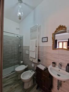 uma casa de banho com um lavatório, um WC e um espelho. em La Barabbata em Marta