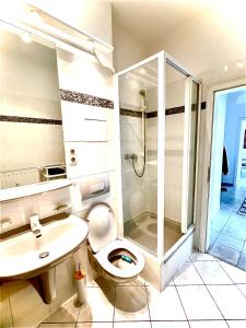 a bathroom with a toilet and a sink and a shower at City Central Hegelstraße in Magdeburg