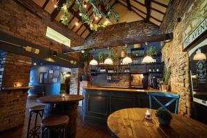 a restaurant with two tables and a bar at The Loft @ The Old George Inn in South Cerney