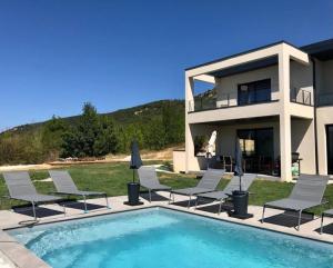 a villa with a swimming pool and chairs and a house at Villa de 6 chambres avec piscine privee jardin clos et wifi a Saint Peray in Saint-Péray