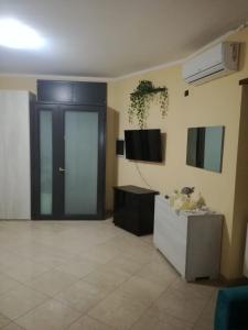 a large room with a door and a tv on the wall at Casa Lulù in Santa Maria La Carità