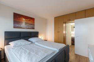 a bedroom with a large bed with white sheets at Haus Frische Brise Sahlenburg Wohnung 12 7 in Sahlenburg
