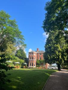 uma grande casa de tijolos com um relvado verde em frente em Kateshill House Bed & Breakfast em Bewdley