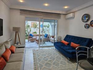 a living room with a blue couch and chairs at Villa Jasmin Super equipped apartment with Garden, Swimming pool, Sea in Hammamet