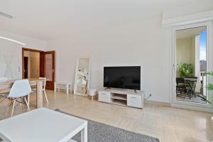 a white living room with a tv and a table at City Escape with City Views ID29 in Luxembourg