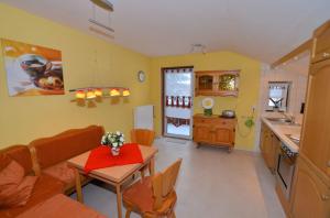 a living room with a table and a kitchen at Haus Rosenbühl in Warmensteinach