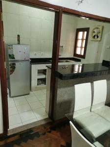 cocina con nevera, mesa y sillas en Oásis Tropical: Flat de Luxo na Beira, Moçambique, en Beira