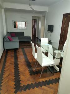 een woonkamer met een bank en een tafel en stoelen bij Oásis Tropical: Flat de Luxo na Beira, Moçambique in Beira