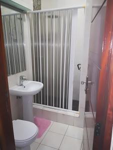 a bathroom with a toilet and a sink and a shower at Oásis Tropical: Flat de Luxo na Beira, Moçambique in Beira