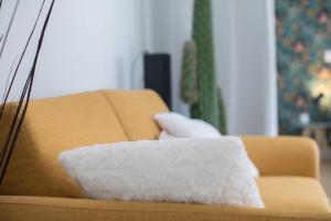 a white pillow sitting on a brown couch at Appartement Cosy proche Arc Triomphe - 2P in Paris