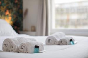 un grupo de toallas sentadas encima de una cama en Appartement Cosy proche Arc Triomphe - 2P, en París 7 fotos más