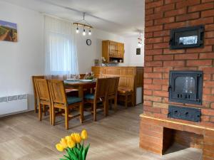 Rakamaz的住宿－Tufa Vendégház，厨房以及带桌子和壁炉的用餐室。