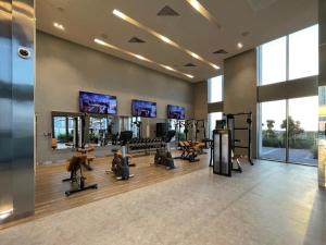 een fitnessruimte met loopbanden en fitnessapparatuur in een gebouw bij Silkhaus elegant 1BDR pad with Marina and Beach views new building in Dubai