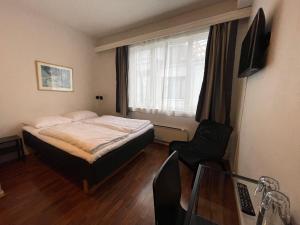 1 dormitorio con 1 cama, 1 silla y 1 ventana en P-Hotels Oslo, en Oslo