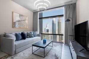 a living room with a couch and a large window at Silkhaus contemporary 1BDR with Downtown view in DIFC in Dubai