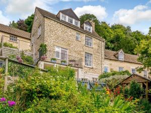 an exterior view of a large brick building with flowers at 3 Bed in Nailsworth 78968 in Nailsworth