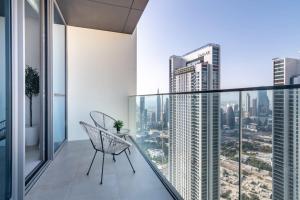 d'un balcon avec une chaise et une vue sur la ville. dans l'établissement Silkhaus homely 2BDR with stunning Downtown view with Balcony, à Dubaï