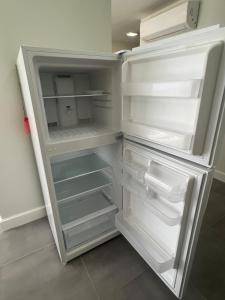 a white refrigerator with its door open with its door open at Cozzy Apartment on the Caribbean side-Frigate Bay in Frigate Bay