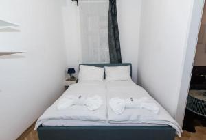 uma cama com lençóis brancos e toalhas em Justus I levestate em Viena