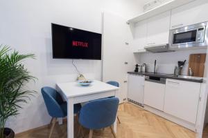 uma cozinha com uma mesa branca e cadeiras azuis em Justus I levestate em Viena