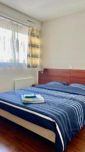 1 dormitorio con 1 cama grande con manta azul en T2 avec petite vue mer avec accès plage, en Bénodet
