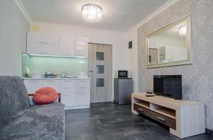 a living room with a couch and a kitchen at OMMPBooking wspólna łazienka in Częstochowa