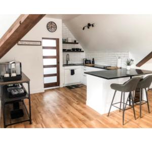 a kitchen with white cabinets and a black counter top at Etherington Suites in Elora