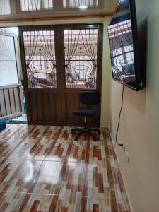 ein Zimmer mit einem Stuhl und einem Fernseher an der Wand in der Unterkunft aparta estudio cerca al aeropuerto espectacular 2 in Bogotá + 10 Fotos