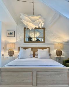 ein Schlafzimmer mit einem Bett mit zwei Lampen und einem Spiegel in der Unterkunft Blas at Fronlas Café - The heart of Newport in Newport